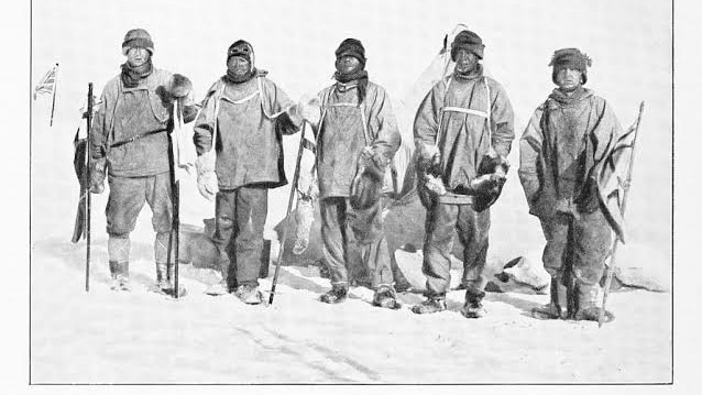 5 men standing in the snow in Antarctica
