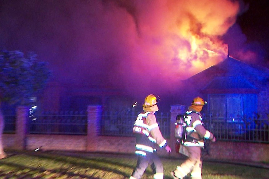 Firefighters outside a large blaze in a home.