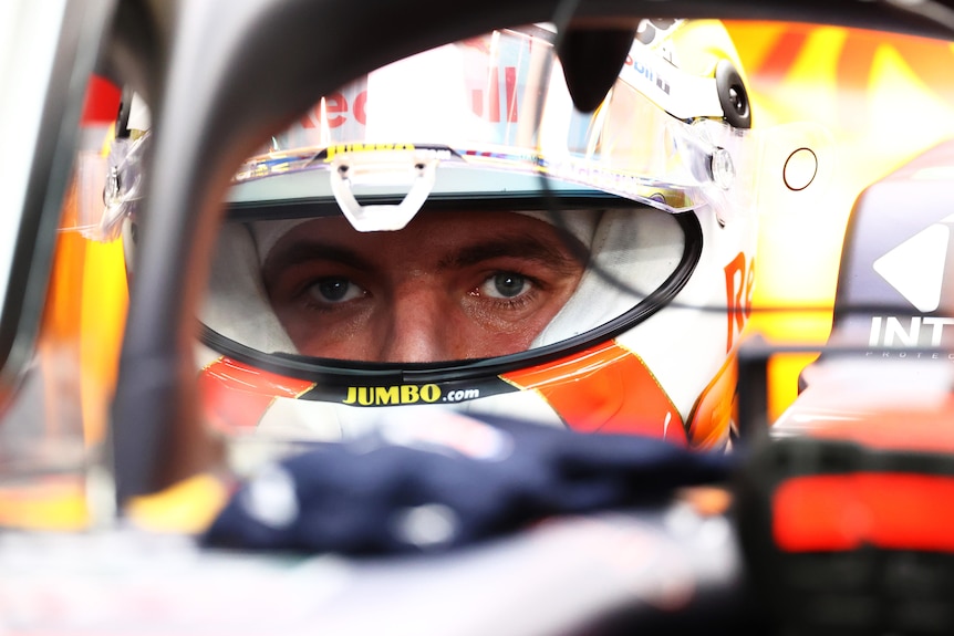 Race driver in his car, looking through his visor.