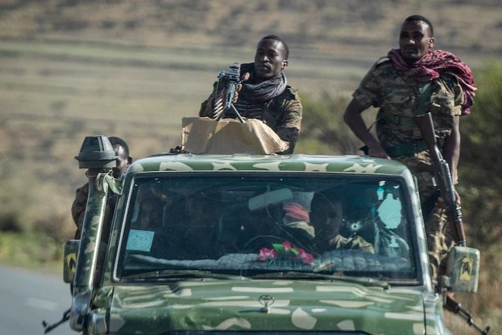 a group of men carrying guns in  truck