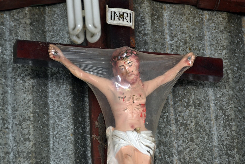 A plastic-wrapped Jesus Christ on the wall of a building at Mo Coi Vinh Son 4.