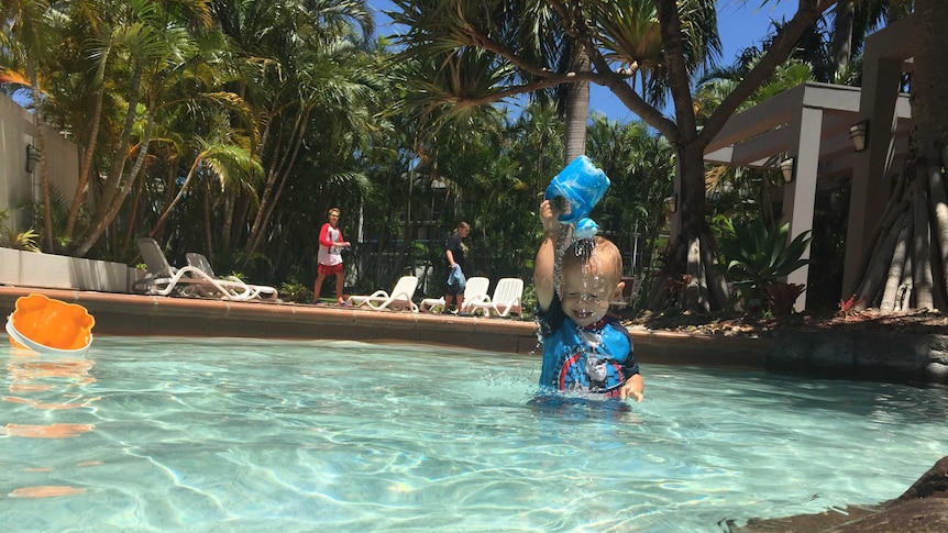 Baby Leo splashes in the water on a hot day