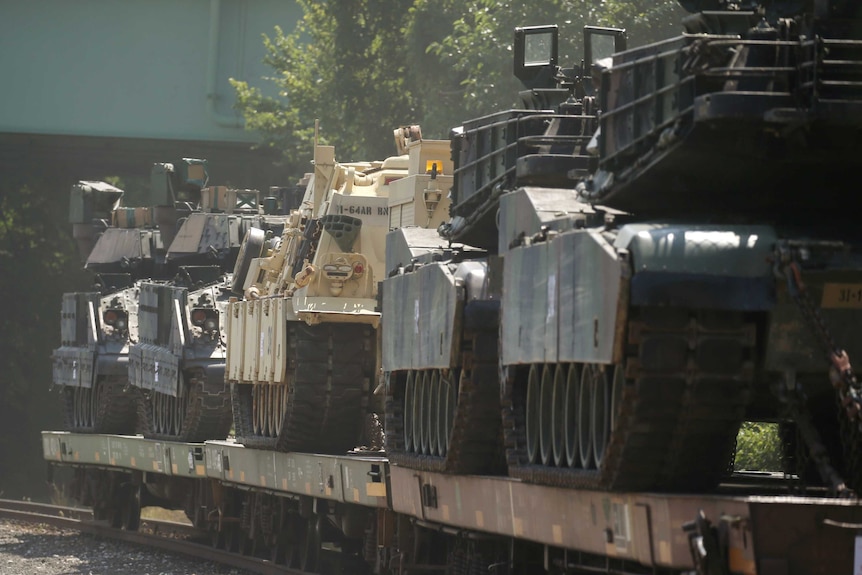 Tanks on top of flat cars