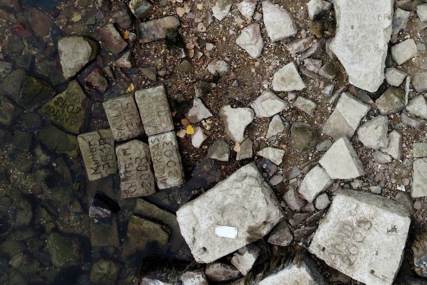 Aerial view of a lakkebed with multiple large rectangular stones. The stones each have different years carved into them