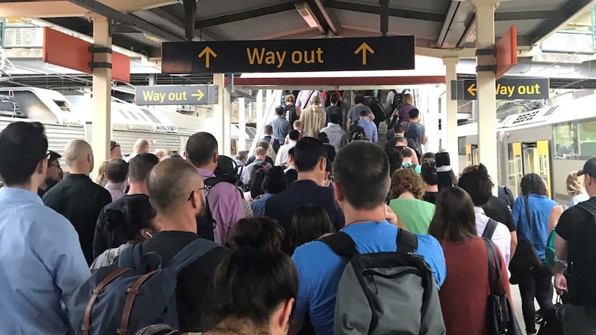 people crowding on a train platform heading up stairs