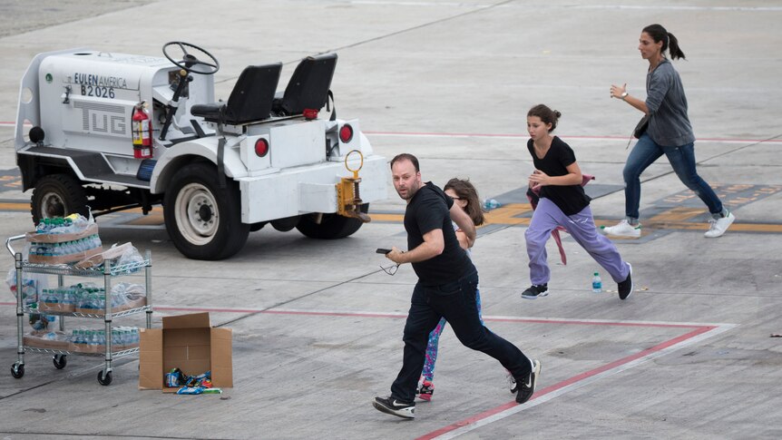 People run on the tarmac at Fort Lauderdale airport