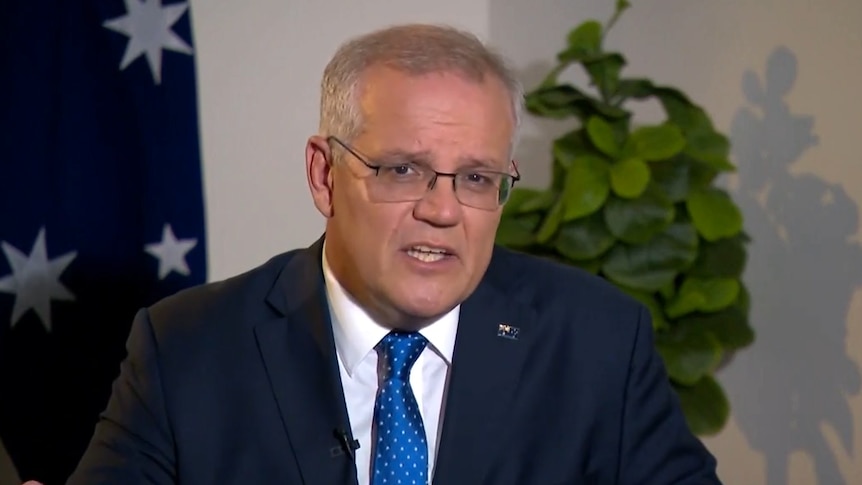 A man in a suit gives a sit down interview on television