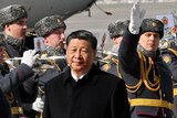 Chinese President Xi Jinping walks past honour guards in Moscow.