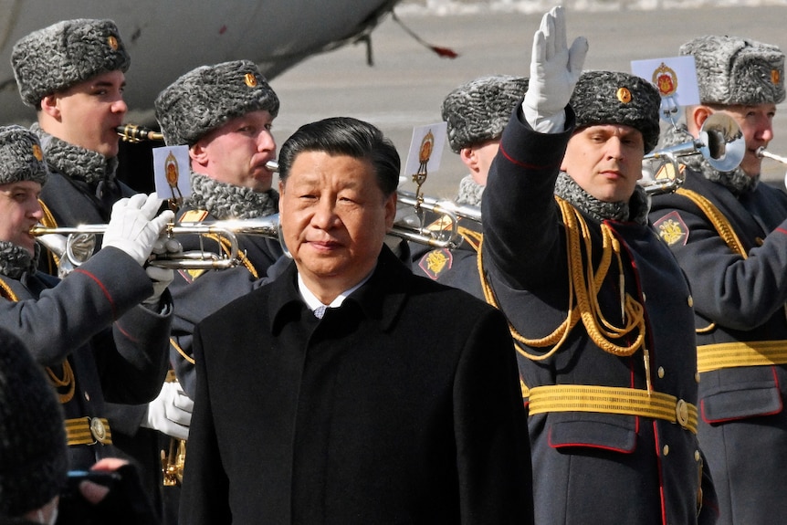 Chinese President Xi Jinping walks past honour guards in Moscow.