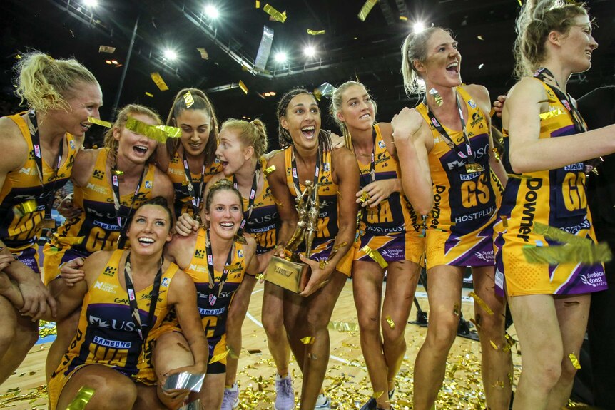 Lightning players celebrate with the Super Netball trophy