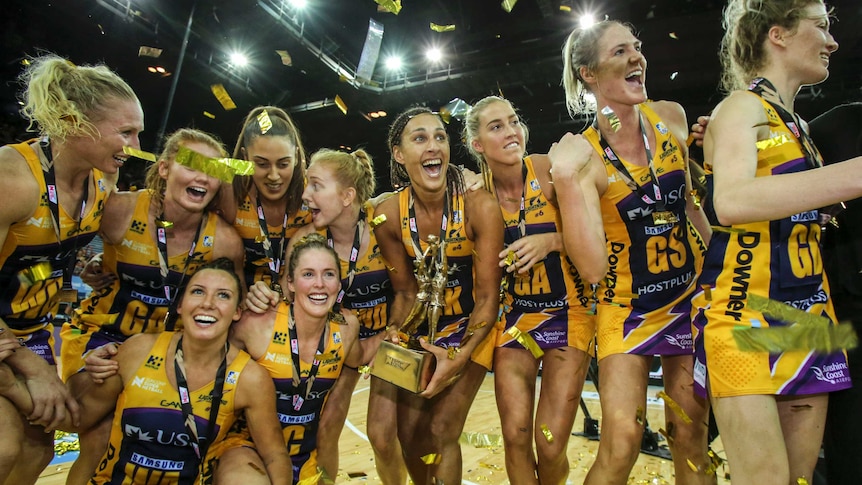 Lightning players celebrate with the Super Netball trophy