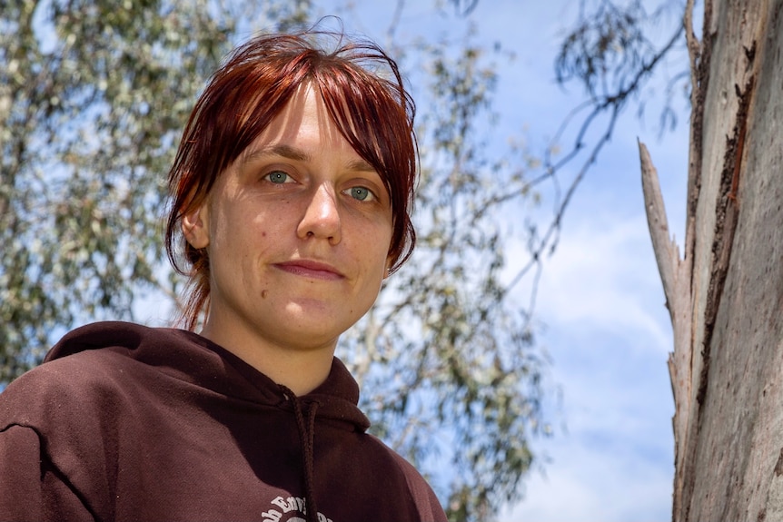 A woman standing next to a tree