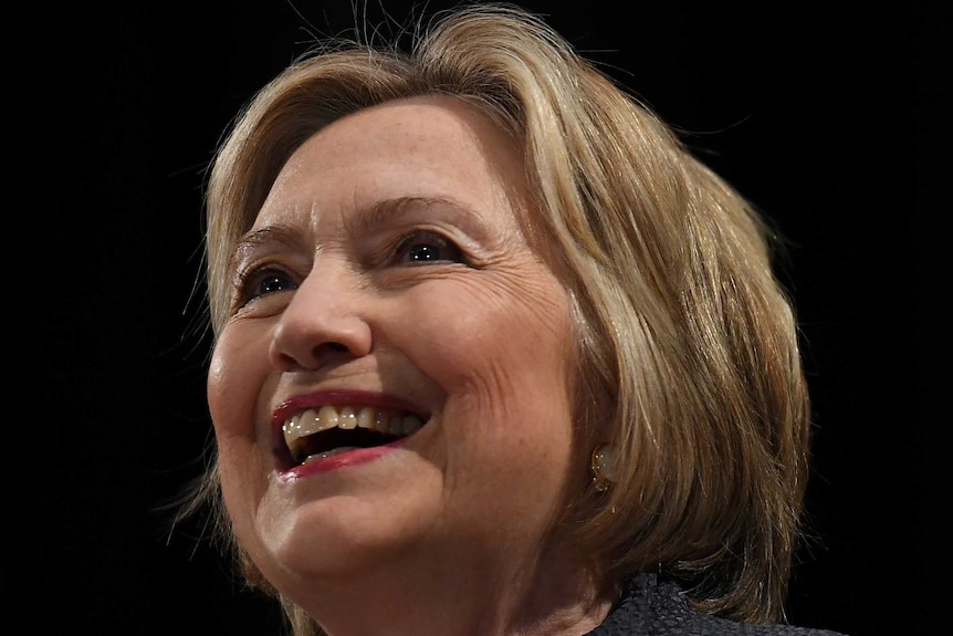 Hillary Clinton smiling in front of a black background