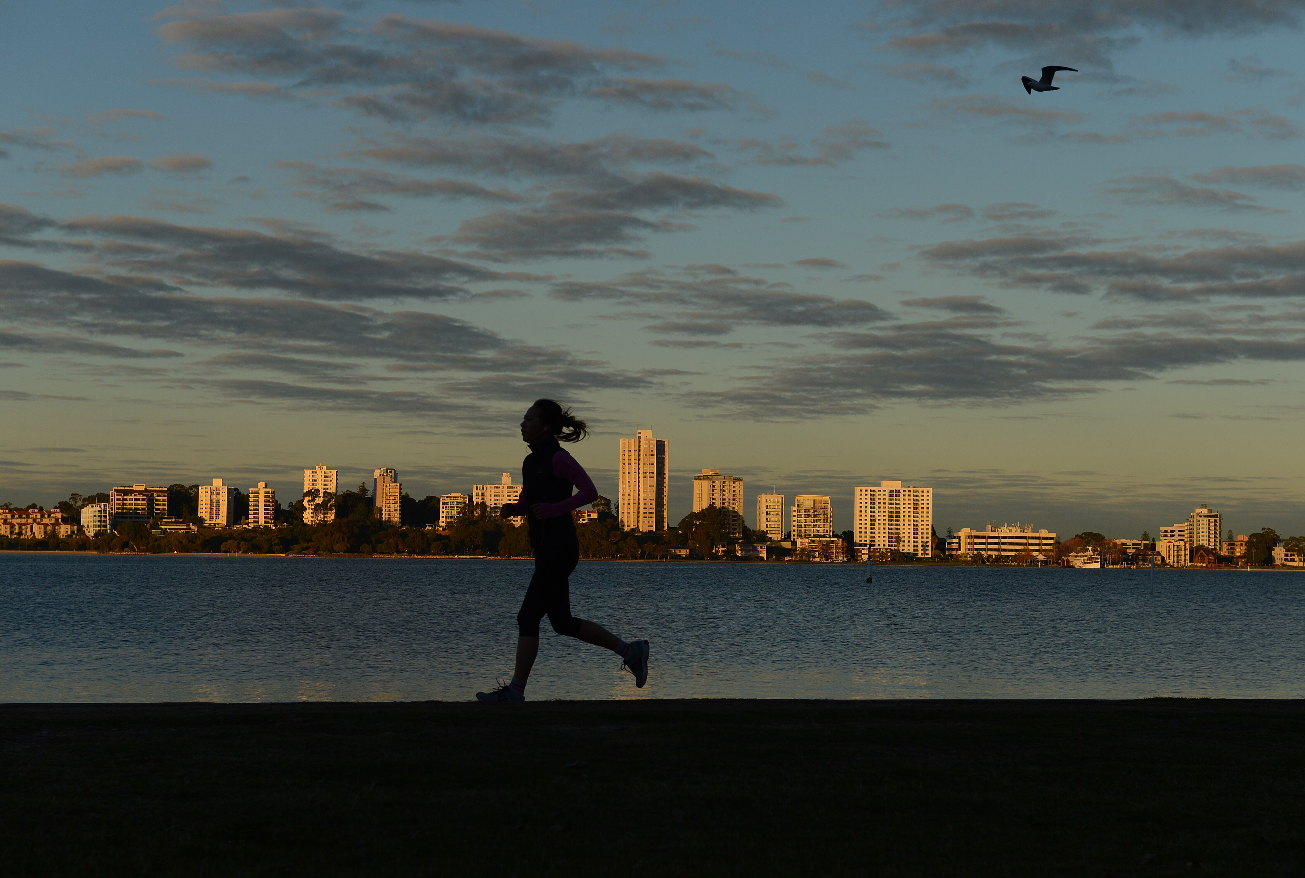 Woman runs around the Swan River in Perth
