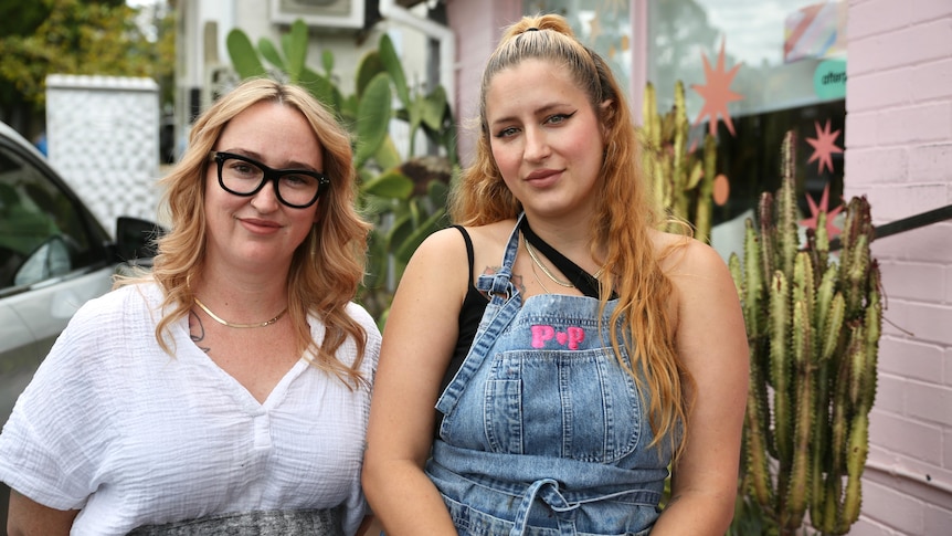 Jasmine and Rachael stand side-by-side outside their salon.