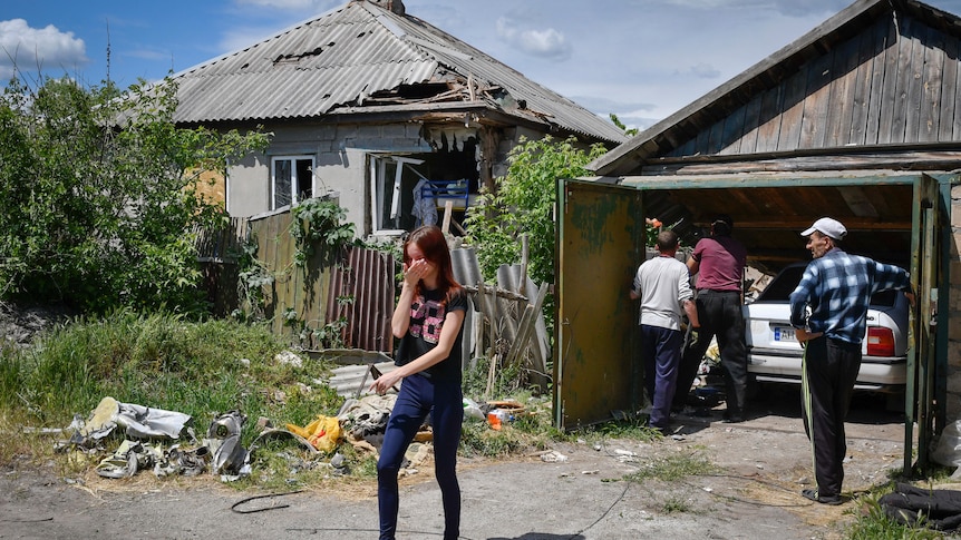 Residents remove debris from a destroyed house