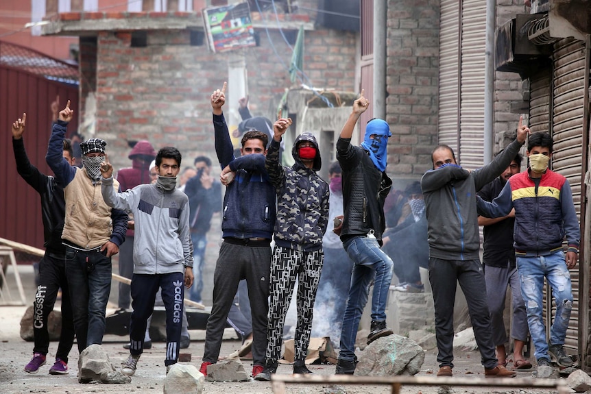 A group of men with their hands in the air during a protest