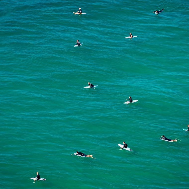 Surfers relax in the water.