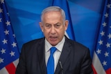 Benjamin Netanyahu speaks in front of US and Israeli flags
