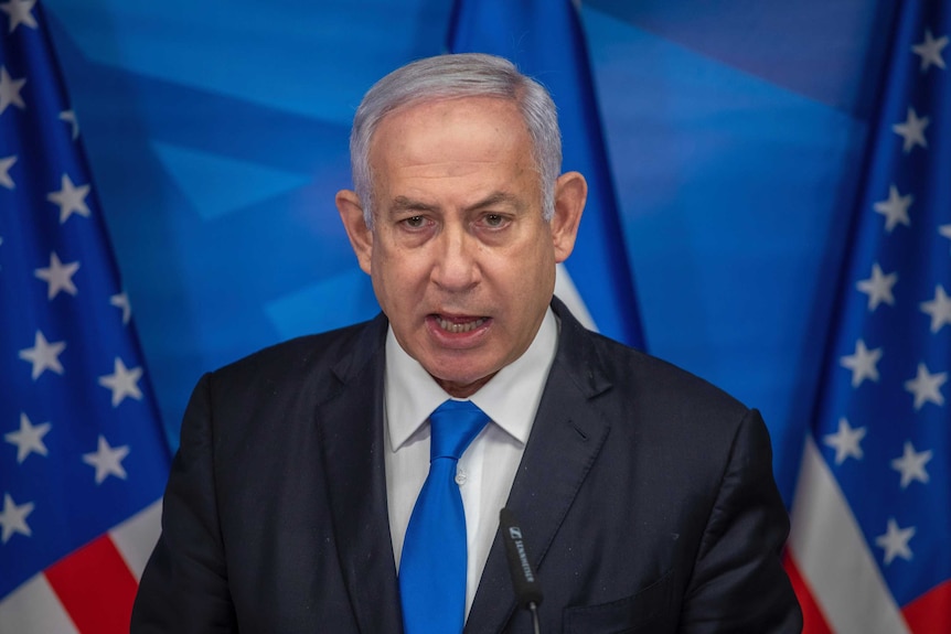 Benjamin Netanyahu speaks in front of US and Israeli flags