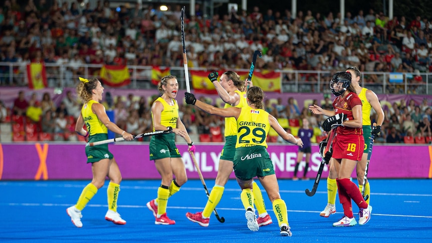Teammates celebrate with Renee Taylor as she scores against Spain at the Women's Hockey World Cup