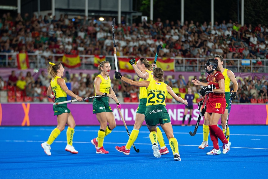 Teammates celebrate with Renee Taylor as she scores against Spain at the Women's Hockey World Cup