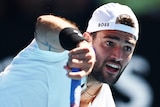 An Italian tennis player serves during an Australian Open match.