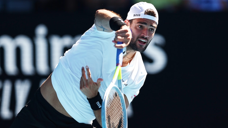 An Italian tennis player serves during an Australian Open match.