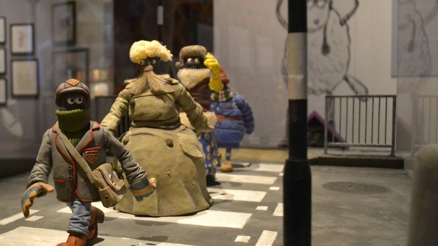 An assortment of characters off the back of Wallace and Gromit series crossing a claymation street.