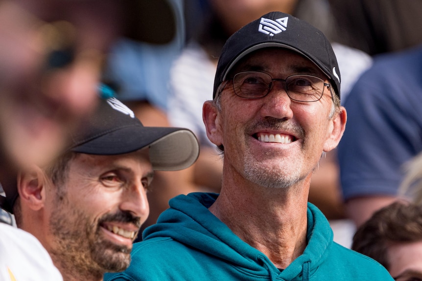 Darren Cahill smiles as he looks on in the stands at the 2024 Australian Open.