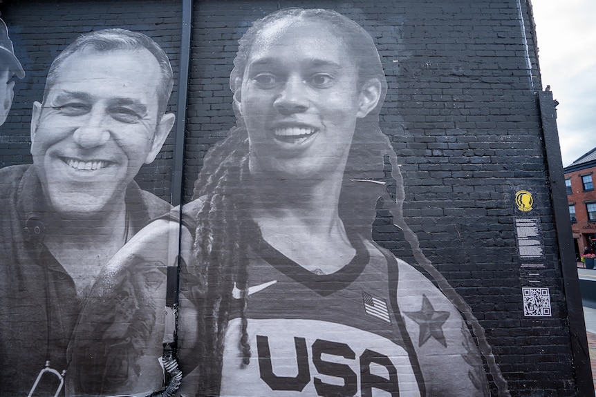 A grey-scale image of US basketballer Brittney Griner painted on a black brick wall
