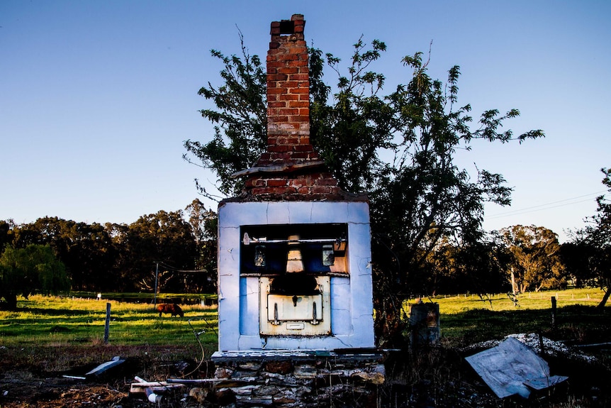 A brick chimney and a Metters stove the only things that remaining of a ruined farmhouse