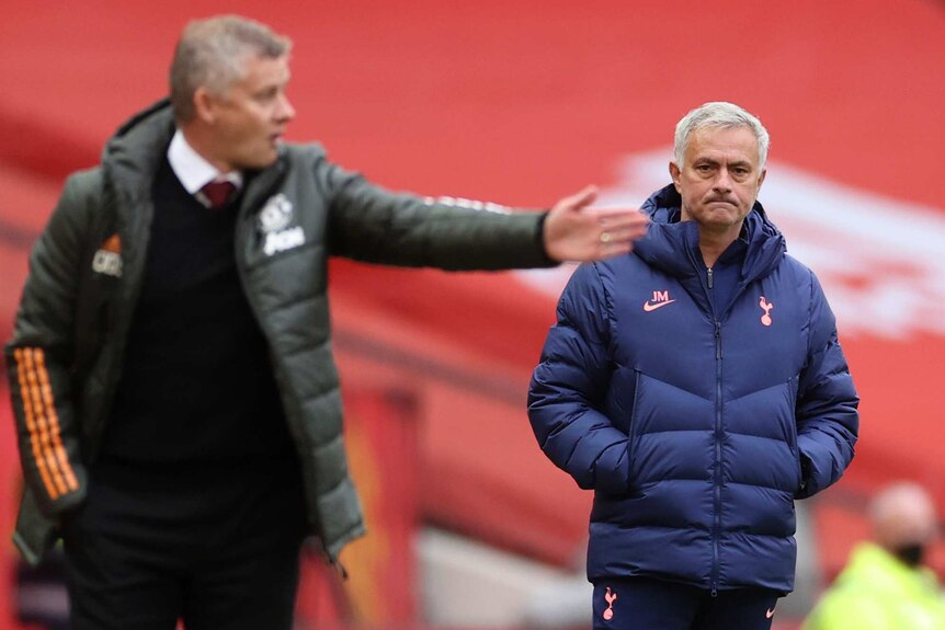 Jose Mourinho looks on with his hands in his pockets as Ole Gunnar Solskjaer points in the foreground