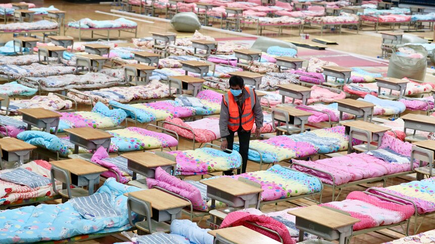 Rows and rows of beds with pink and blue sheets.