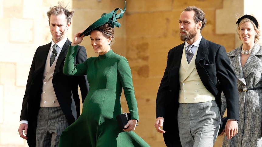 A heavily pregnant Pippa Middleton arrives at a wedding wearing an olive green coat and matching facinator
