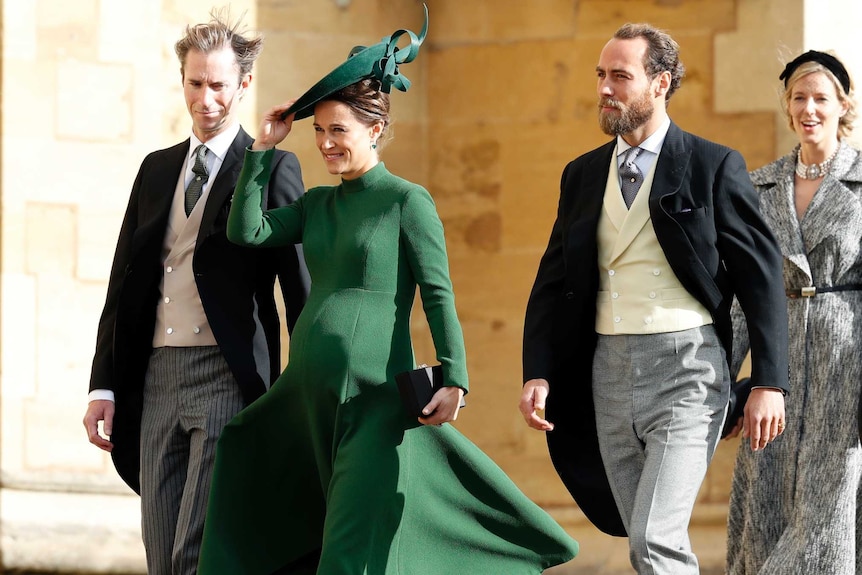 A heavily pregnant pippa middleton arrives at a wedding wearing an olive green coat and matching facinator