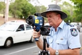 A Queensland police officer operating a roadside speed camera