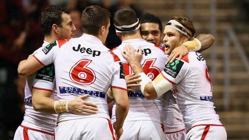 Dragons players celebrate a try against the Panthers