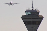 A plane passes a tower