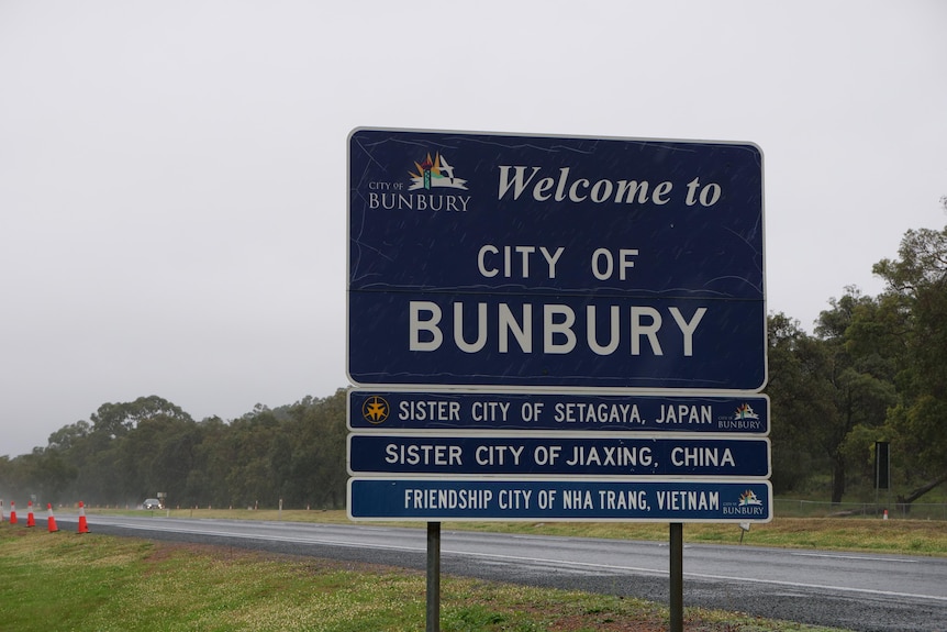 An entry sign that welcomes people to the city of bunbury and mentions the sister city relationships