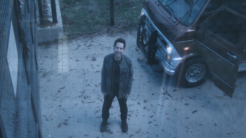 Colour still of Paul Rudd standing in driveway with car and seen through security camera in 2019 film Avengers: Endgame.
