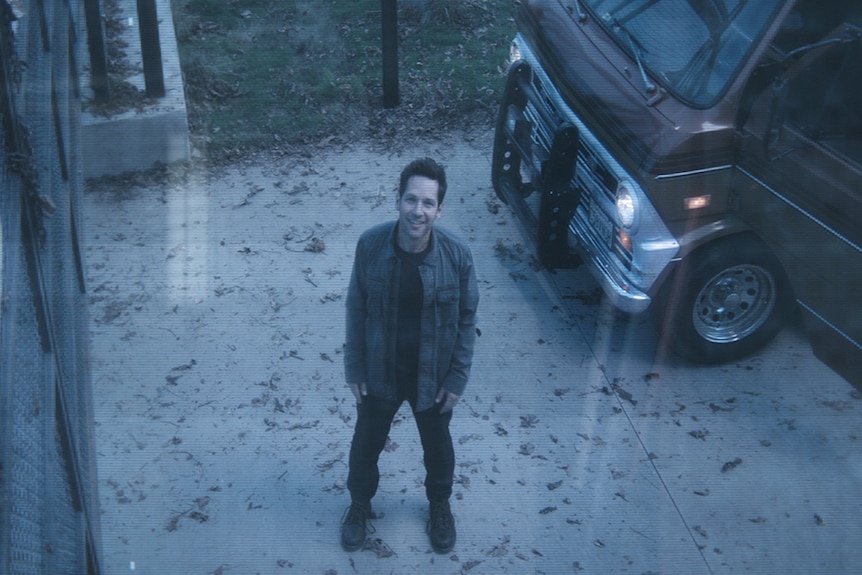 Colour still of Paul Rudd standing in driveway with car and seen through security camera in 2019 film Avengers: Endgame.