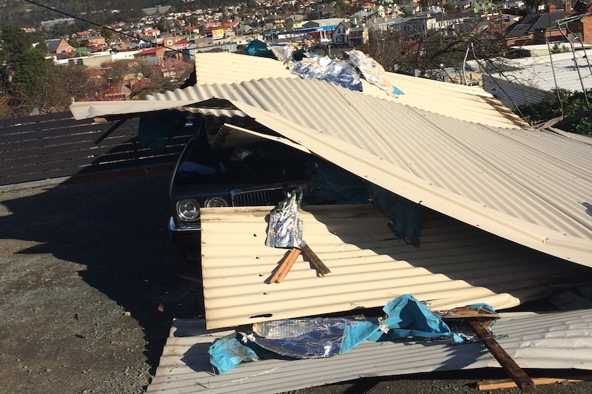 A roof torn from a house lands on a Jaguar in Sandy Bay