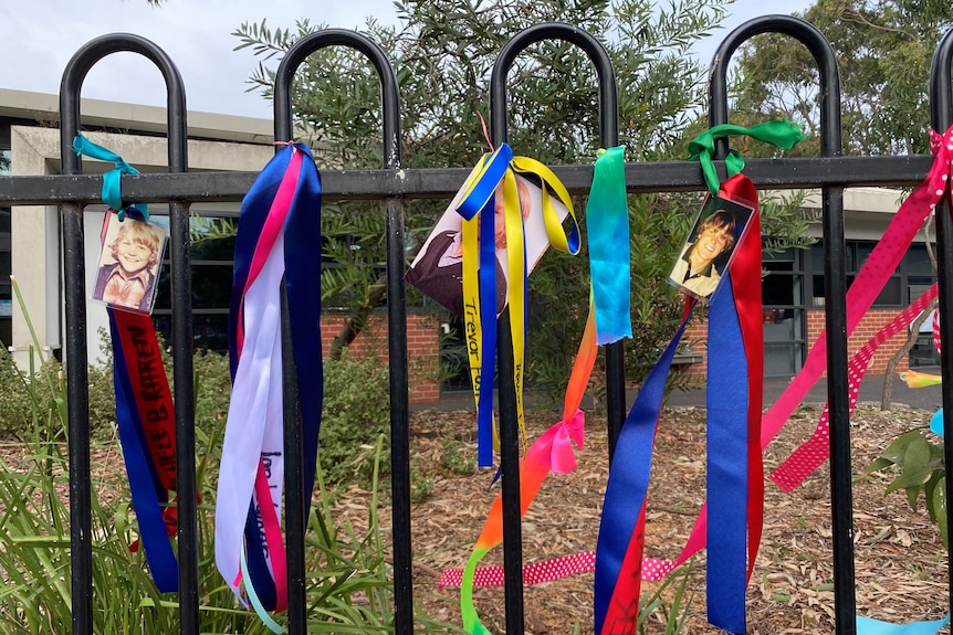 Ribbons attached to photos of schoolboys are tied to the boundary fence of a primary school. 