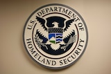 The US Department of Homeland Security emblem on a wall.