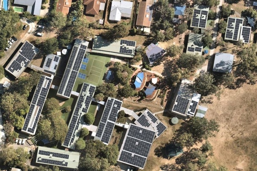 Aerial view of a school with solar panels on top.