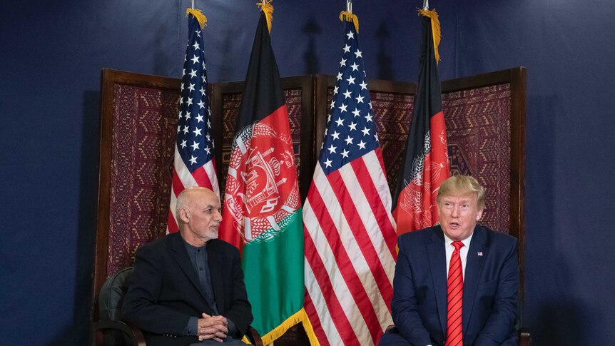 President Donald Trump and Afghan President Ashraf Ghani sit side by side in front of flags