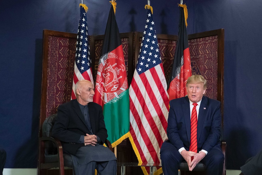 President Donald Trump and Afghan President Ashraf Ghani sit side by side in front of flags