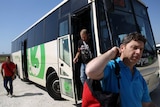 Palestinian workers disembark from an Israeli bus near the West Bank town of Qalqily
