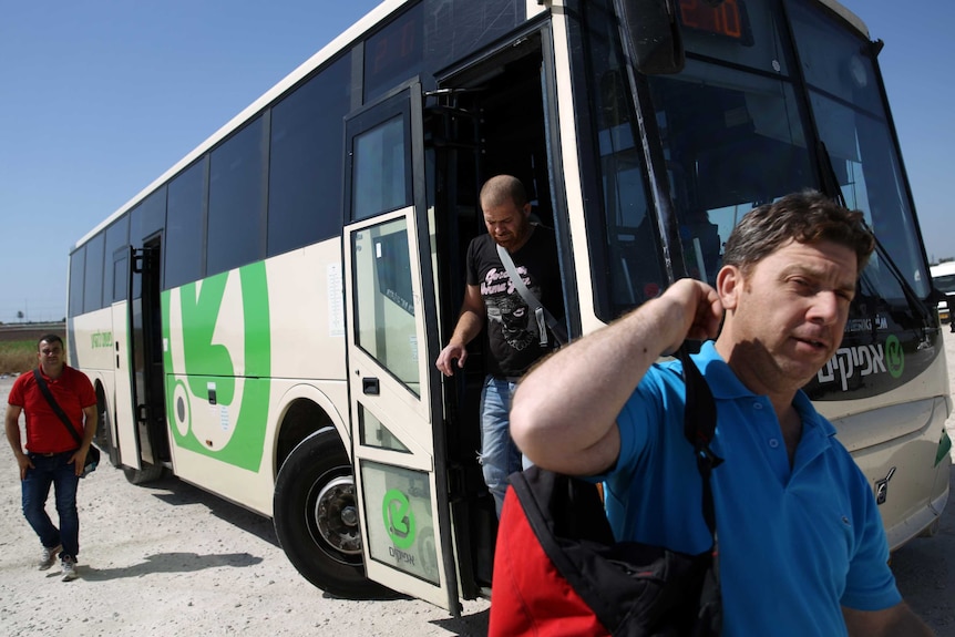 Palestinian workers disembark from an Israeli bus near the West Bank town of Qalqily